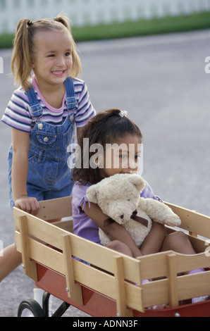 Deux filles jouant avec un push cart Banque D'Images