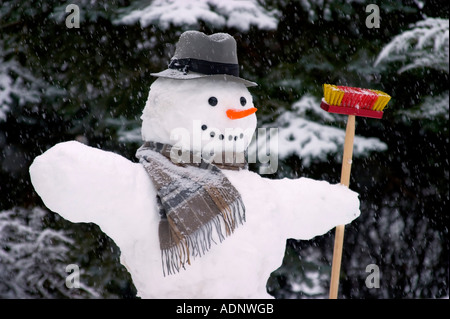 Le Snowman avec chapeau, foulard et balai Banque D'Images