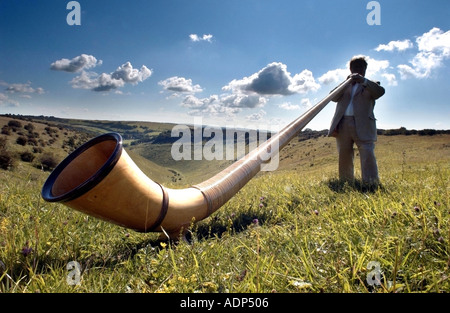 Un homme jouant le cor des alpes ou cor des Alpes Suisse étrange instrument de musique. Banque D'Images