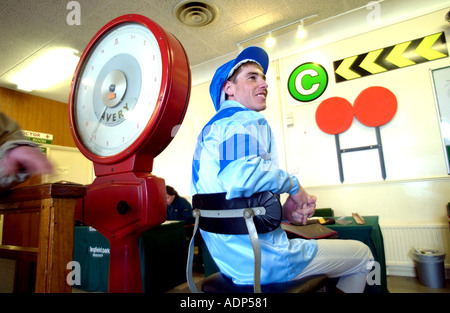 En pesage. Un jockey dans ses soies sur la balance avant sa race Banque D'Images