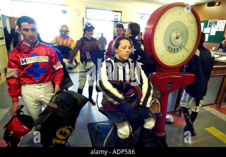 Pesée en une femme jockey dans la sellette avant sa race Banque D'Images