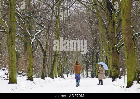 Scène d'hiver en couple marcher ensemble sur la neige couverts Hampstead Heath North London United Kingdom Banque D'Images