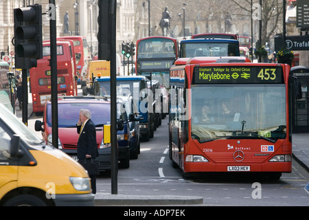 Le trafic lourd à l'arrêt aux feux de circulation à Trafalgar Square Londres Angleterre Royaume-uni centre-ville Banque D'Images