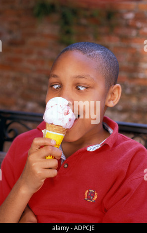 African American boy avec brain freeze depuis eating ice cream cone Banque D'Images