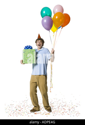 Homme avec party hat holding balloons et boîte-cadeau Banque D'Images