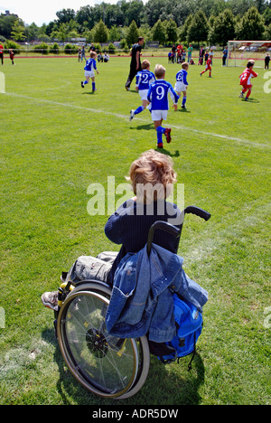 Dans le fauteuil roulant enfant regardant un match de foot, Allemagne Banque D'Images