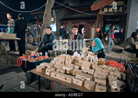 La CHINE XI'AN scène de nuit de location fournisseurs avec leurs chariots sur le trottoir dans le quartier musulman de Xi'an vieux Banque D'Images