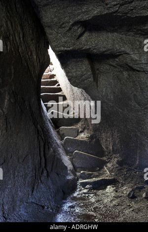 [Huayna Picchu], Sculpté en pierre étroites mesures Inca menant hors de la petite grotte de montagne sombre, le Pérou, Amérique du Sud' Banque D'Images