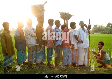 Un entrepreneur vend antenne pour les riziculteurs sur son téléphone mobile à énergie solaire dans un village près de Comilla Bangladesh 2006 Banque D'Images