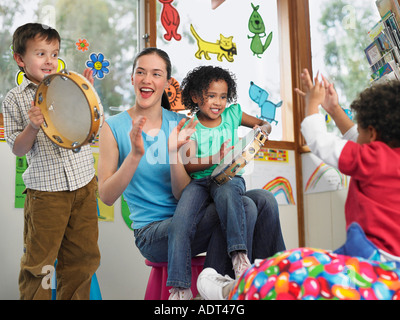 Les enfants avec l'enseignant à jouer de la musique en classe Banque D'Images