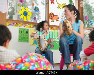 Les enfants avec l'enseignant à jouer de la musique en classe Banque D'Images