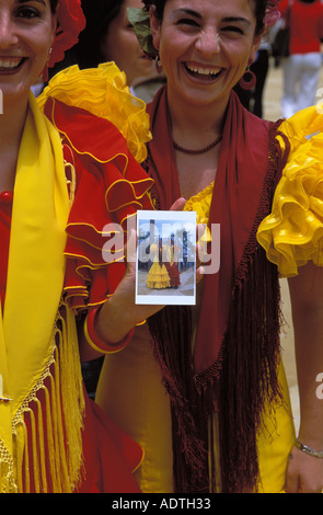Séville deux femmes en robe de flamenco avec un polaroid à la feria de abril Banque D'Images