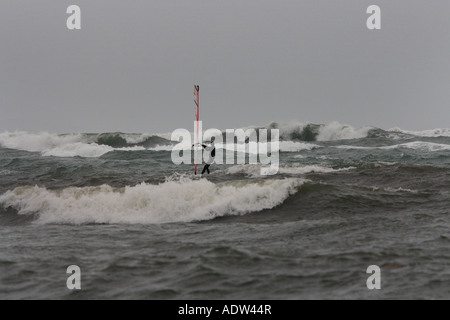Windsurfer brave les grosses vagues sur un mauvais temps venteux jour étés à kimmeridge bay dorset Banque D'Images