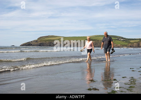 À maturité, d'âge moyen, les personnes âgées, en couple, homme et femme, pagayer dans le Pembrokeshire Newport mer peu profonde de l'ouest du pays de Galles de l'été Banque D'Images