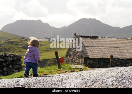 Jeune fille (18 mois) marche sur chemin croft, Uig, Isle Of Lewis, Scotland, Royaume-Uni. Août 2007 Banque D'Images
