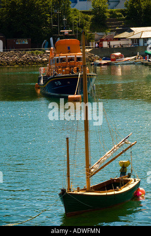 Bateau à voile en bois amarré à Brixham avec un bateau de la RNLI en arrière-plan Banque D'Images