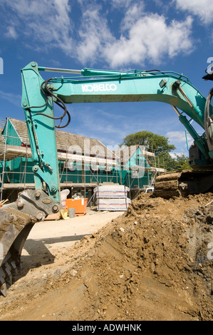 Nouvelles maisons en construction pour l'association du logement social CANTREF digger vert à l'avant-plan de Pembrokeshire Newport West Wales UK Banque D'Images