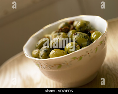 Bol d'olives vertes marinées avec des herbes Banque D'Images
