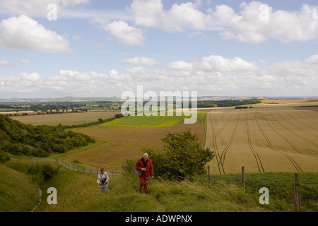 Randonneurs à pied le sentier donnant sur un crop circle à Vale de Pewsey Wiltshire England Royaume-Uni Banque D'Images