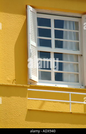 Fenêtre balcon volets Architecture ferroviaire rideaux détail façade jaune ocre ombre soleil architecture concept construction Banque D'Images