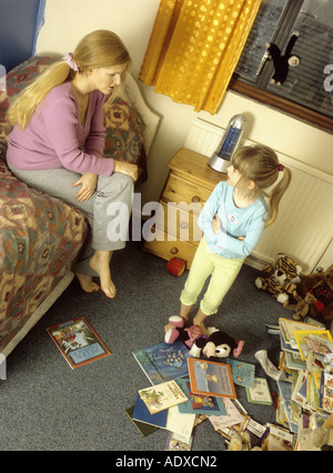 Mère d'avoir une discussion avec son enfant au sujet de sa chambre en désordre Banque D'Images