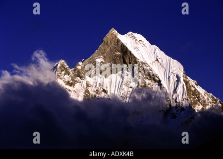 Machhapuchhare et nuages dans le sanctuaire de l'Annapurna au Népal Banque D'Images