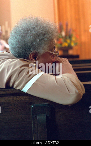 Femme 65 ans assis pensivement en service à l'église après pew. St Paul Minnesota USA Banque D'Images