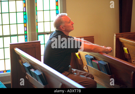 Homme 58 ans assis à l'église priant pew. Western Springs Illinois USA Banque D'Images