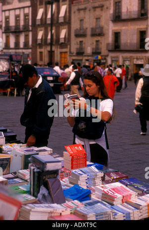Femme mexicaine mexicains woman looking at books affichage aux libraires Zocalo Mexico District Fédéral, Mexique Banque D'Images