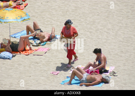 La tentative de vente de melon et les tranches d'ananas aux personnes sur la plage de Palma Nova, à Majorque. Banque D'Images