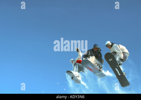 Snowboarder trois en plein ciel, saut côte à côte Banque D'Images