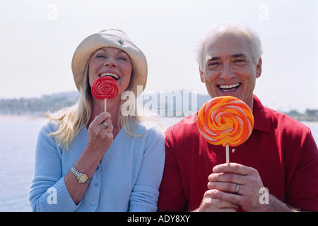 Portrait de Couple Eating Lollipops Banque D'Images