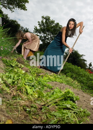 Deux jeunes femmes en tenue de soirée jardinage légumes Banque D'Images