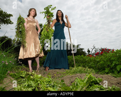 Deux jeunes femmes en tenue de soirée jardinage légumes Banque D'Images