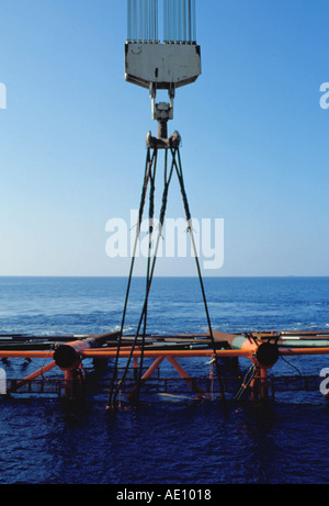 La plate-forme pétrolière jacket soulevée en position inclinée par une grue flottante Banque D'Images