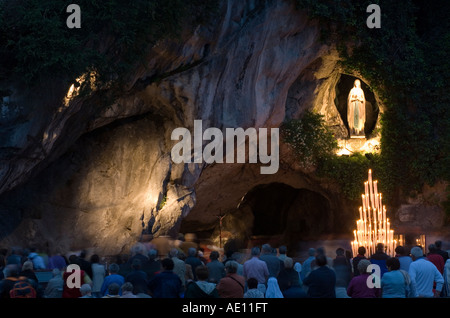 Pèlerins priant devant la Grotte de Massabielle à Lourdes la nuit, France Banque D'Images