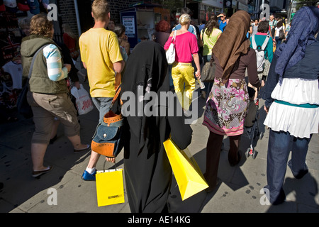 Une femme asiatique avec des sacs jaunes du magasin Selfridges sur Oxford Street, London, England, UK Banque D'Images