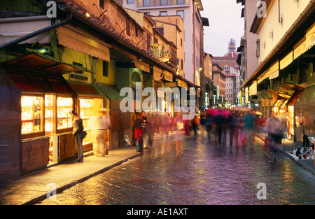 Italie Toscane Florence Ponte Vecchio Scène de rue au crépuscule avec doublure devantures le pont et les gens en mouvement floue Banque D'Images