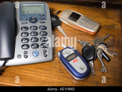 Trois téléphones et deux jeux de clés sur la table dans la chambre Banque D'Images