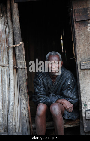 Vieil homme assis dans son logement en village Evatra, Fort Dauphin, Madagascar Banque D'Images