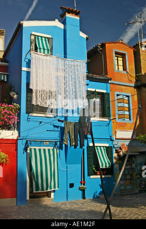 Accrocher des rideaux à l'extérieur d'une maison bleue pour sécher Banque D'Images