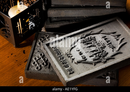 Plateau en relief en briques sur une table près d'une bougie allumée. Banque D'Images