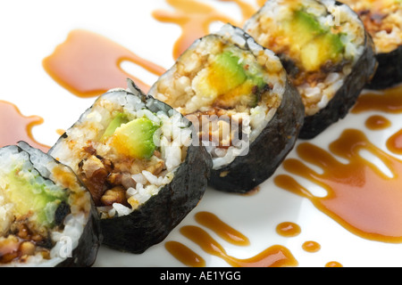 Un plat de sushi japonais sur un plat et orné de sauce douce. Banque D'Images