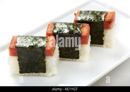 Un plat japonais sur un plateau composé de trois morceaux de riz d'une enveloppe. Banque D'Images