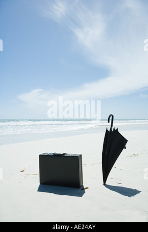 Porte-documents et son parapluie sur sunny beach Banque D'Images