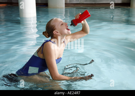 Young woman on exercise bike in spa pool Banque D'Images