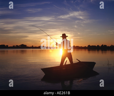 L'homme de pêche barque au coucher du soleil sur la Floride USA Lake Banque D'Images