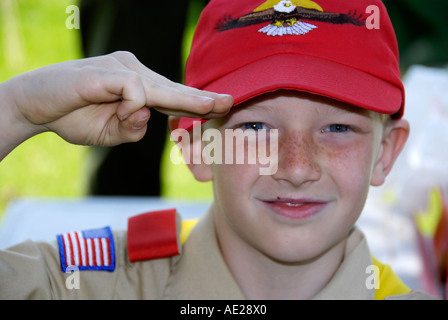 Boy-scout en uniforme réalise trois fabricants salute Banque D'Images