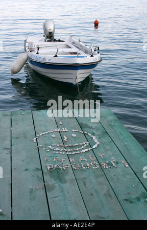 Cailloux laissés par les enfants avec smiley face on Jetty, tard en soirée, Lefkas Nidri Grèce Banque D'Images