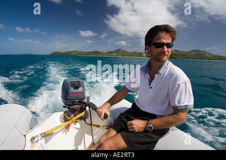 Canot hors-bord sur l'homme dans les eaux tropicales des Îles Fidji dans le Pacifique Sud Banque D'Images